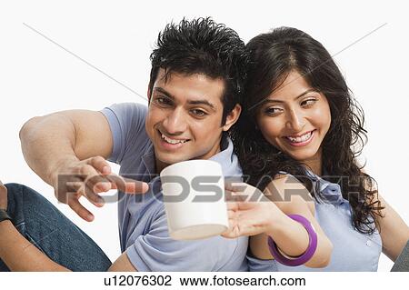 Woman giving a cup of coffee to her boyfriend View Large Photo Image Stock Image - Woman giving a cup of coffee to her boyfriend. Fotosearch