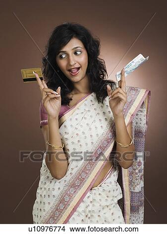 Woman holding a credit card and a currency note View Large Photo Image Picture - Woman holding a credit card and a currency note. Fotosearch