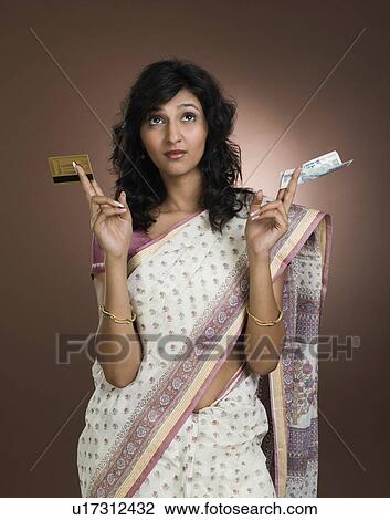 Woman holding a credit card and a currency note View Large Photo Image Stock Image - Woman holding a credit card and a currency note. Fotosearch