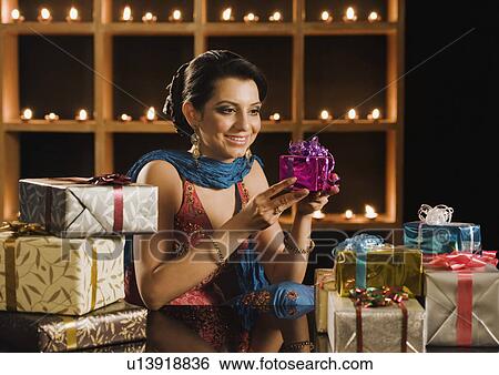 Woman holding a Diwali gift and smiling View Large Photo Image Stock Photograph - Woman holding a Diwali gift and smiling. Fotosearch