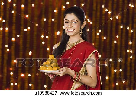 Woman holding a plate full of sweets View Large Photo Image Stock Photo - Woman holding a plate full of sweets. Fotosearch