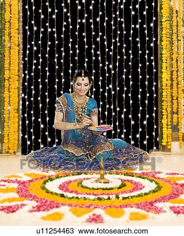 Woman holding a plate of powder paints to make rangoli at Diwali festival View Large Photo Image Stock Image - Woman holding a plate of powder paints to make rangoli at Diwali festival. Fotosearch