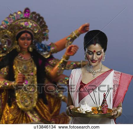 Woman holding a pooja thali at Durga puja festival View Large Photo Image Picture - Woman holding a pooja thali at Durga puja festival. Fotosearch