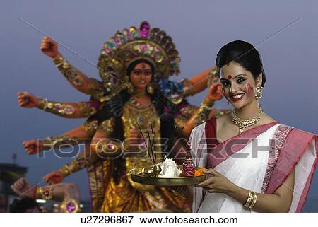 Stock Photo - Woman holding a pooja thali at Durga puja festival. Fotosearch