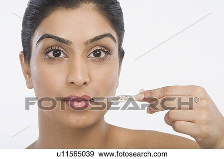 Stock Photo - Woman holding a thermometer. Fotosearch