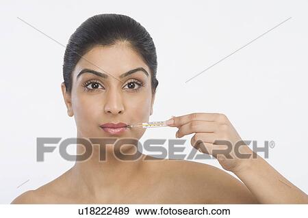 Woman holding a thermometer View Large Photo Image Stock Photo - Woman holding a thermometer. Fotosearch