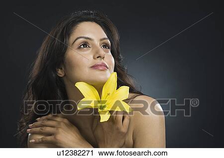 Woman holding a Tiger Lily flower and day dreaming View Large Photo Image Stock Image - Woman holding a Tiger Lily flower and day dreaming. Fotosearch