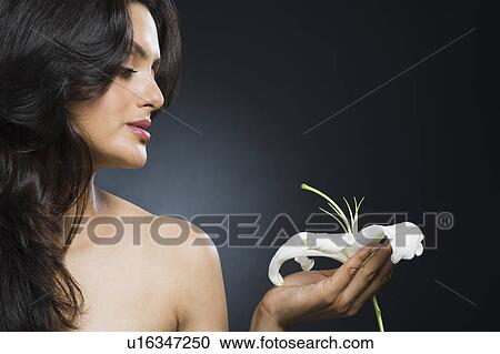 Stock Image - Woman holding a Tiger Lily flower. Fotosearch
