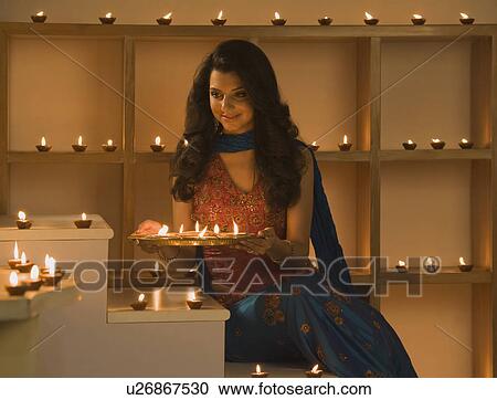 Woman holding a traditional Diwali thali and smiling View Large Photo Image Stock Image - Woman holding a traditional Diwali thali and smiling. Fotosearch