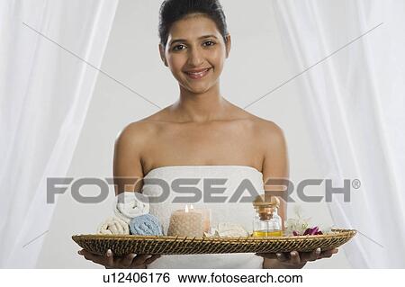 Woman holding a tray of spa products and smiling View Large Photo Image Stock Photograph - Woman holding a tray of spa products and smiling. Fotosearch