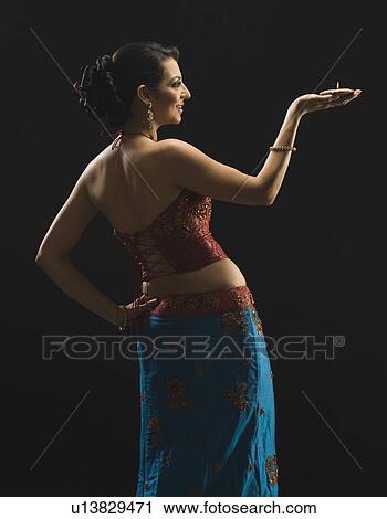 Woman holding an oil lamp and smiling View Large Photo Image Stock Image - Woman holding an oil lamp and smiling. Fotosearch