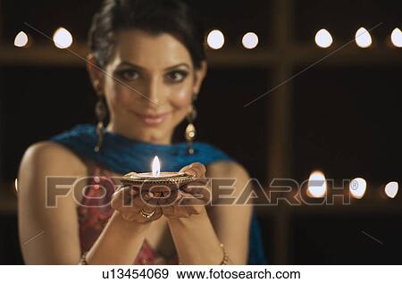 Woman holding an oil lamp and smiling View Large Photo Image Stock Photo - Woman holding an oil lamp and smiling. Fotosearch