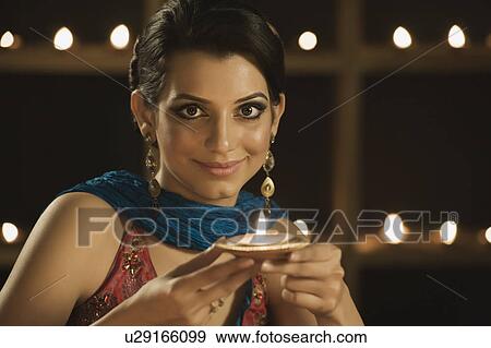 Woman holding an oil lamp and smiling View Large Photo Image Stock Photo - Woman holding an oil lamp and smiling. Fotosearch