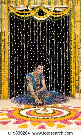 Woman holding an oil lamp in Diwali festival View Large Photo Image Picture - Woman holding an oil lamp in Diwali festival. Fotosearch