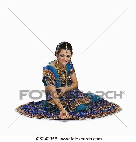 Woman holding an oil lamp in Diwali festival View Large Photo Image Stock Photo - Woman holding an oil lamp in Diwali festival. Fotosearch