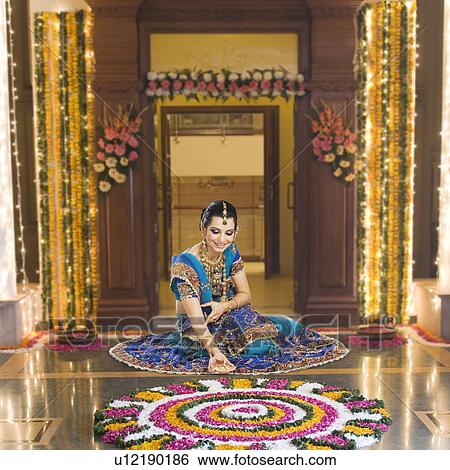 Stock Photograph - Woman holding an oil lamp in Diwali festival. Fotosearch