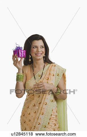 Woman holding Diwali gift and smiling View Large Photo Image Stock Photo - Woman holding Diwali gift and smiling. Fotosearch
