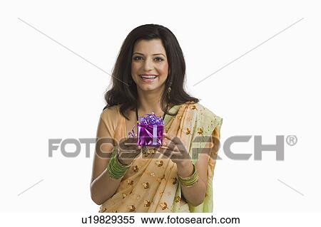 Woman holding Diwali gift and smiling View Large Photo Image Stock Photography - Woman holding Diwali gift and smiling. Fotosearch