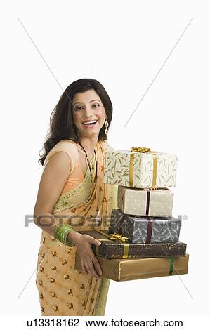 Stock Image - Woman holding Diwali presents and smiling. Fotosearch