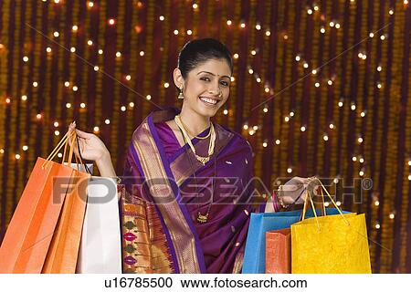 Stock Image - Woman holding shopping bags. Fotosearch