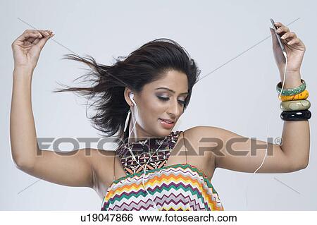 Stock Photograph - Woman listening to music and dancing. Fotosearch