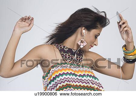 Stock Photograph - Woman listening to music and dancing. Fotosearch