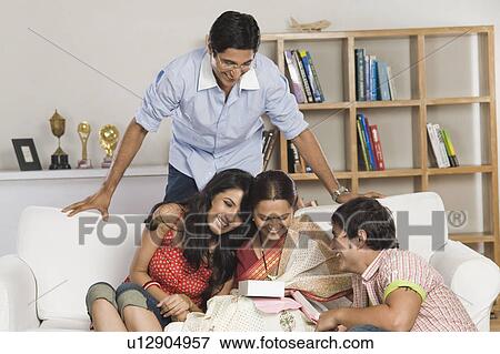 Woman looking at a gift and smiling View Large Photo Image Stock Photo - Woman looking at a gift and smiling. Fotosearch