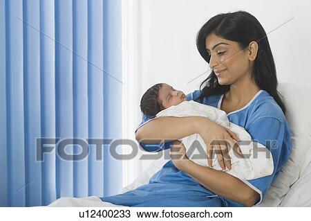 Woman looking at her baby on the bed View Large Photo Image Stock Image - Woman looking at her baby on the bed. Fotosearch