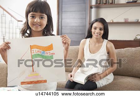 Stock Photography - Woman looking at her daughter showing drawing of Indian flag. Fotosearch