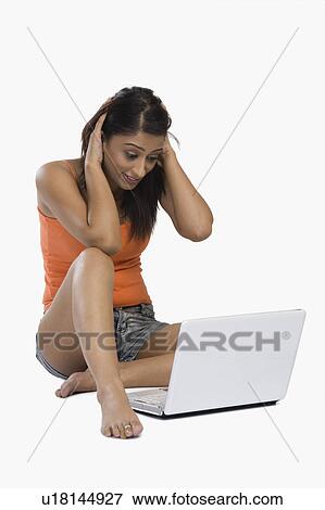 Woman looking confused in front of a laptop View Large Photo Image Stock Photo - Woman looking confused in front of a laptop. Fotosearch