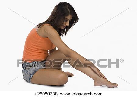 Stock Photo - Woman massaging her leg. Fotosearch