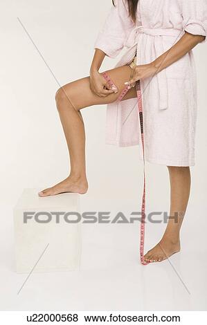Woman measuring her thigh View Large Photo Image Stock Photo - Woman measuring her thigh. Fotosearch