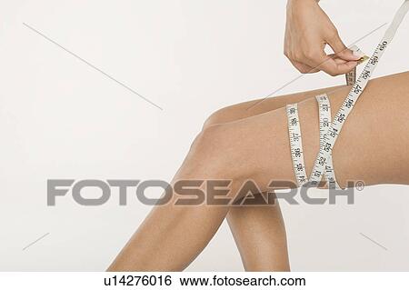 Woman measuring her thigh View Large Photo Image Stock Photograph - Woman measuring her thigh. Fotosearch