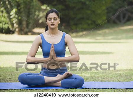 Woman meditating in a park View Large Photo Image Stock Image - Woman meditating in a park. Fotosearch