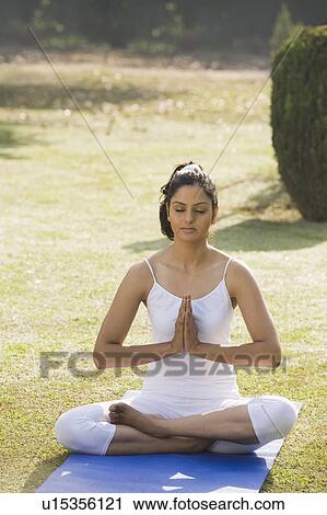 Woman meditating in a park View Large Photo Image Stock Image - Woman meditating in a park. Fotosearch