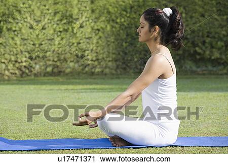 Woman meditating in a park View Large Photo Image Stock Image - Woman meditating in a park. Fotosearch