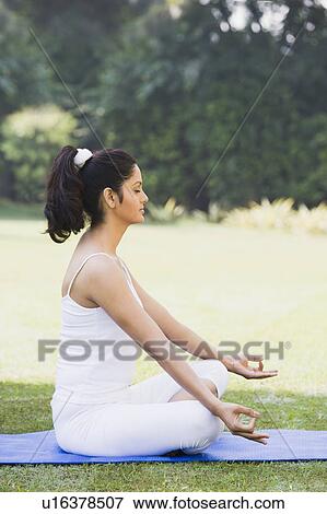 Woman meditating in a park View Large Photo Image Stock Photo - Woman meditating in a park. Fotosearch
