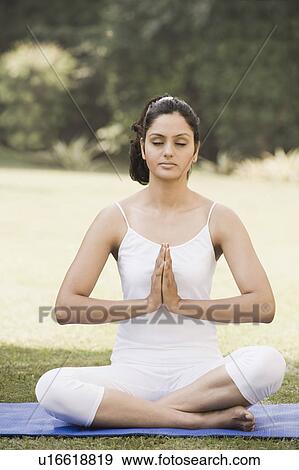 Woman meditating in a park View Large Photo Image Stock Photo - Woman meditating in a park. Fotosearch