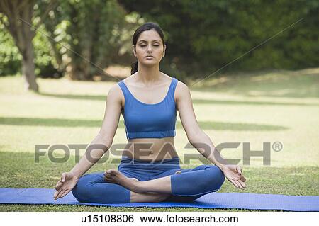 Woman meditating in a park View Large Photo Image Stock Photograph - Woman meditating in a park. Fotosearch