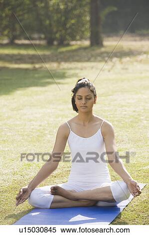 Stock Photography - Woman meditating in a park. Fotosearch