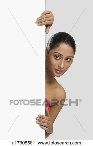 Woman peeking from behind a door View Large Photo Image Stock Image - Woman peeking from behind a door. Fotosearch