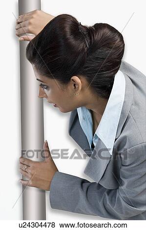 Woman peeking from behind a door View Large Photo Image Stock Photo - Woman peeking from behind a door. Fotosearch