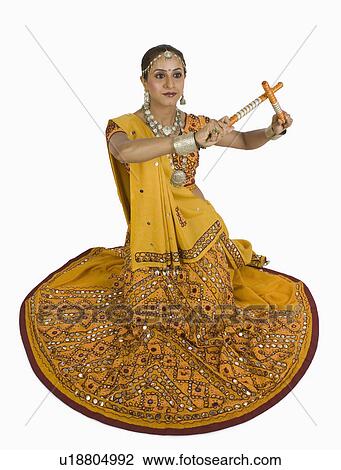 Stock Image - Woman performing dandiya. Fotosearch