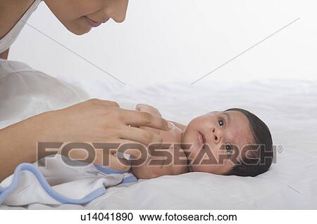Stock Image - Woman playing with her baby. Fotosearch