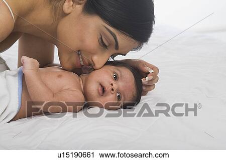 Stock Image - Woman playing with her baby. Fotosearch