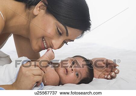Woman playing with her baby View Large Photo Image Stock Photo - Woman playing with her baby. Fotosearch