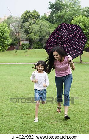 Stock Image - Woman playing with her daughter in a park. Fotosearch