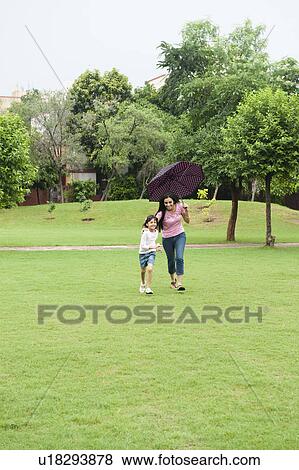 Stock Photo - Woman playing with her daughter in a park. Fotosearch