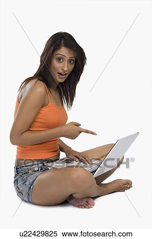 Stock Photography - Woman pointing at a laptop. Fotosearch