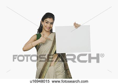Stock Photography - Woman pointing at a whiteboard and smiling. Fotosearch